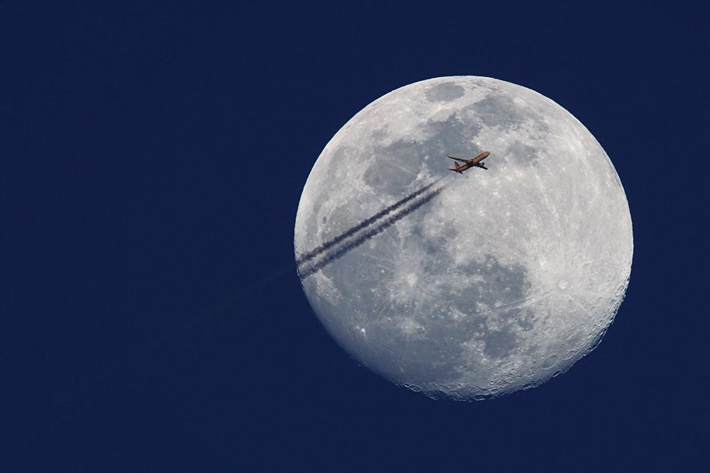 American Airlines passenger jet in front of full Moon