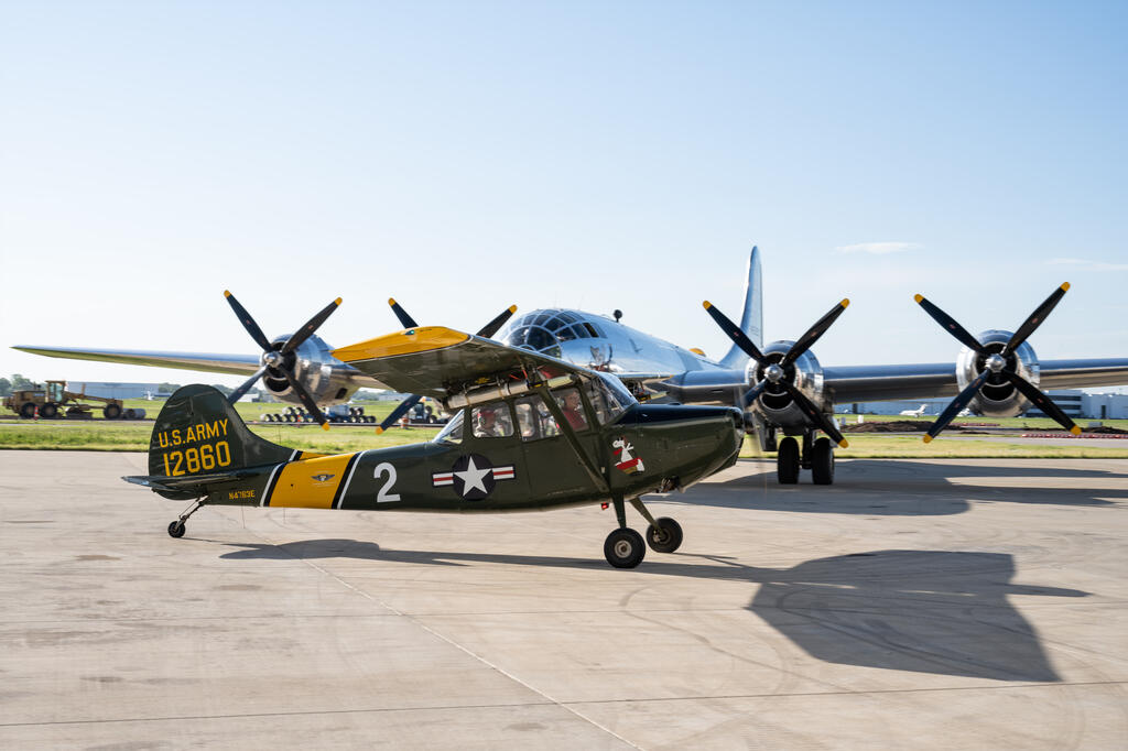 Cessna L-19 Bird Dog taxis past B-29 Doc