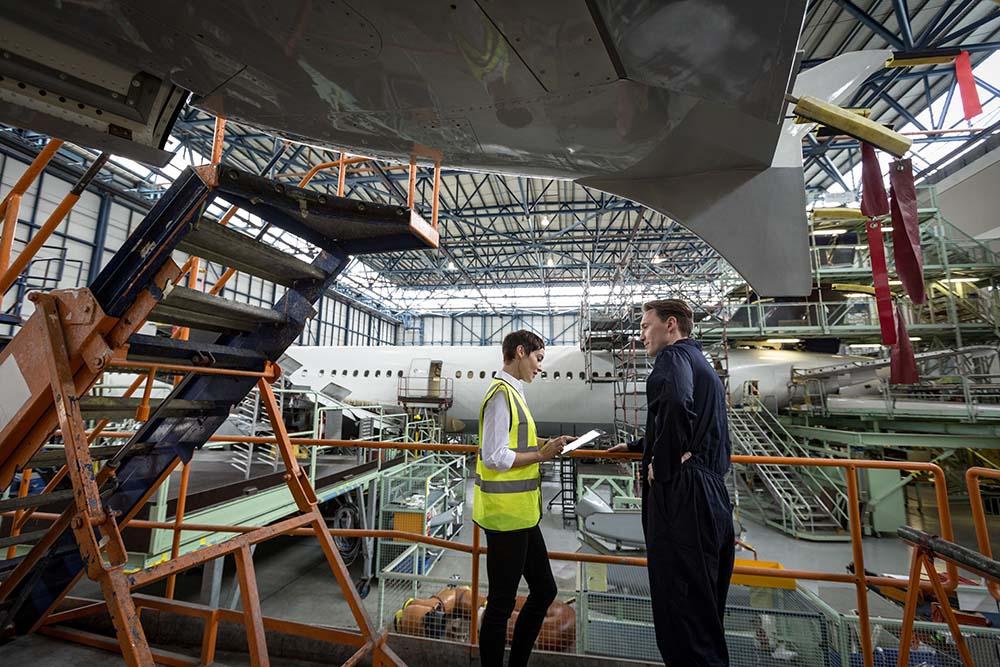 Technicians using a tablet in a maintenance hangar