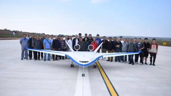 BWB-300 10.3%-scale model on runway with students and designers standing behind it