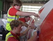 technicians applying film to aircraft